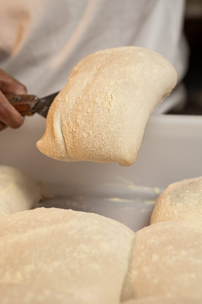 Masa de fermentación lenta con alveolos visibles en pizza artesanal horneada en horno de piedra en Reus